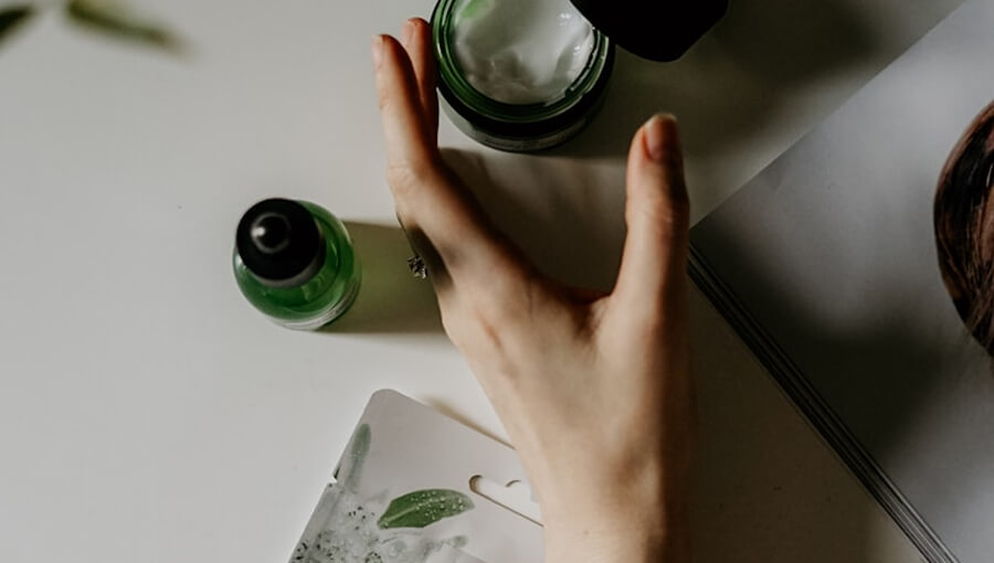 Foto cenital de cremas y mano