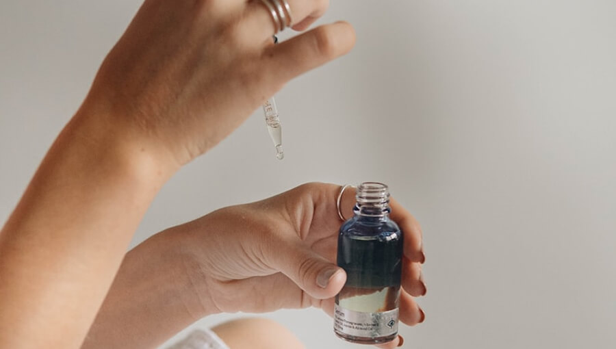 Mano con pipeta y un bote de esencias